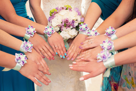 bride and bridesmaids with violet bracelets on handsの写真素材