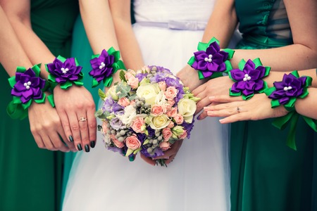 bride with a bouquet and bridesmaids with bracelets of violet colorの写真素材