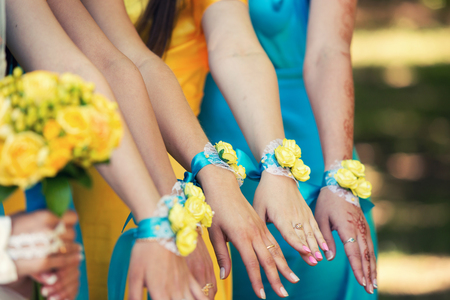bracelets of bridesmaids of yellow color and the bride with a yellow bouquet of rosesの写真素材