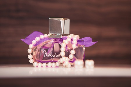 women's perfume of violet color and bracelet from pearls