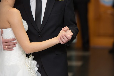 the groom holds the bride by a hand at a weddingの写真素材