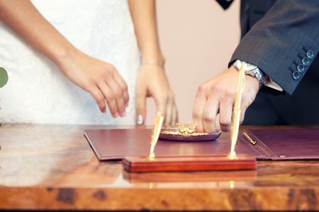 the groom dresses not weight a ring on a finger on wedding registration