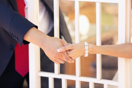 the groom and the bride hold each other by hands