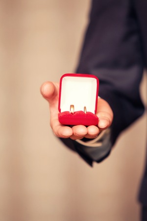 wedding rings in a red box in a hand at the groom