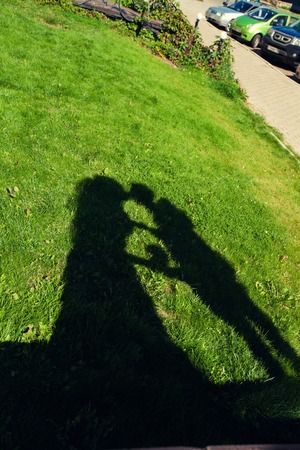 silhouettes of a loving couple on a green grassの写真素材