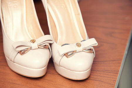 white wedding shoes of the bride with a bowの写真素材