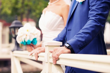 watch of the groom on a hand and the bride from bouquets in handsの写真素材