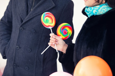 round color sugar candies in hands of the man and womanの写真素材