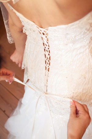 bridesmaids help to dress a wedding dressの写真素材