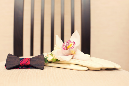 wooden  bow tie of a glove and a buttonhole from an orchidの写真素材