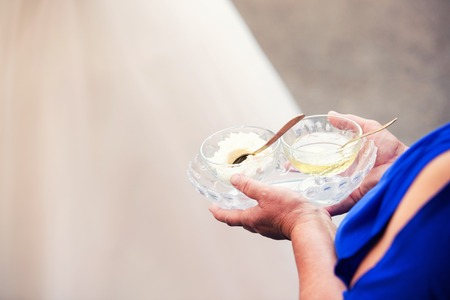 mother of the bride holds in hand honey and oil for a ceremonyの写真素材