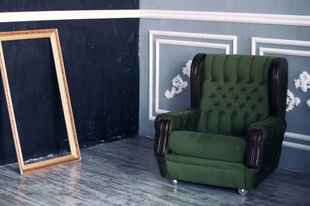 stylish interior in dark tones. Green chair and gold frameの写真素材