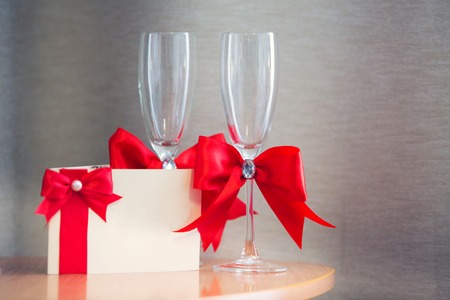 invitation on a wedding and glasses for the newlywed with a red tapeの写真素材