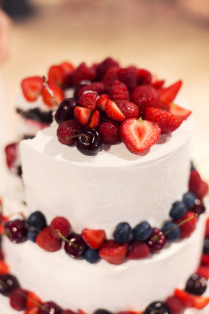 Weding cake with fresh berries. Berries and cherry on a beautiful delicious cake. A wedding cake.の写真素材