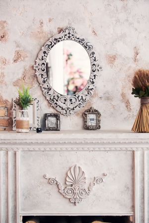 fireplace in classical style and a mirror in an interiorの写真素材
