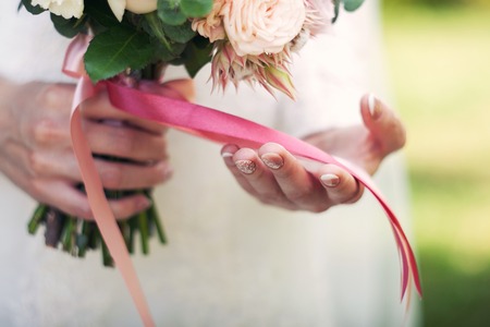 bouquet from roses in the bride's hands. Pink tapesの写真素材