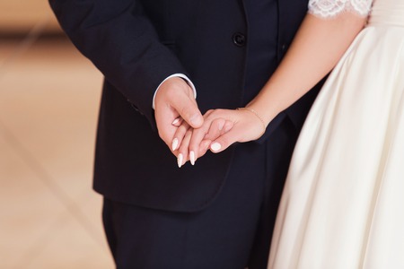 newlyweds hold each other by hands