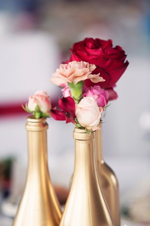 Wedding decor. Golden bottles and red rosesの写真素材