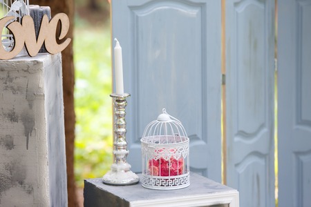 decoration for wedding registration in the form of a bird's cage, blue wooden door and candlesの写真素材