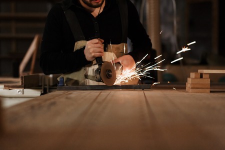 happy young family with the little son in the carpenter workshop. Family business. Startup, young specialist. Place for the text. dark lightingの写真素材