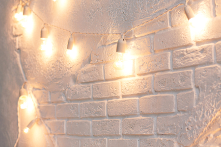 Christmas electric garland on white brick wall backgroundの写真素材