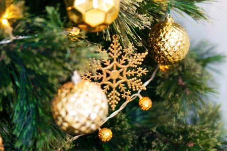 Close up of a Christmas tree and decoration with gold ball on white brick wall background.の写真素材