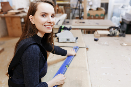 girl works in a carpenters workshop, female small businessの写真素材