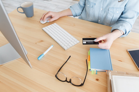 Online shopping. Cropped shot of unrecognizable caucasian female in blue shirt keyboarding on laptop...