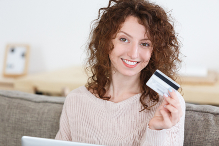 Close up portrait attractive European woman looking at camera with happy expression,surfing websites while shopping online, uses online banking. People and ecommerce conceptの写真素材