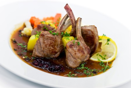 Close up picture of a roasted lamb chop and vegetables
