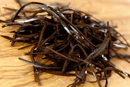 Heap of healthy laminaria and fork in blue plate.の写真素材