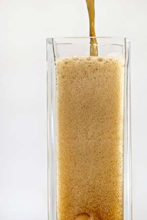 Pouring Cola in to tall glass  Glass filling with bubblesの写真素材