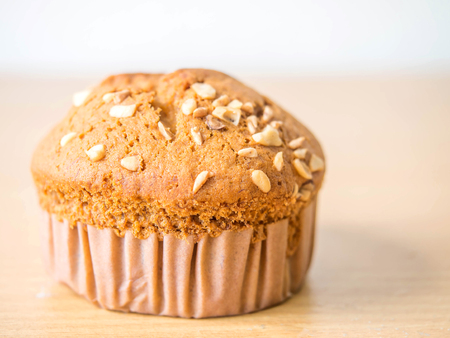 Peanuts on top of Banana cake on a brown and white Background.