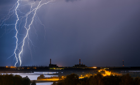 Thunderstorm above power plant with gorgeous lightning at night