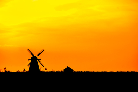 silhouette of an old historic windmill at sunsetの写真素材