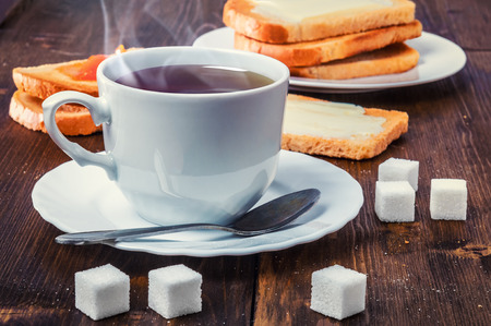 Healthy breakfast with cup of tea, bread, butter and jamの写真素材