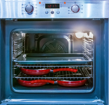 Close up of demonstrating the space inside the empty electric oven with switched inner light