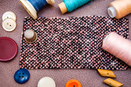 Colorful bobbins, buttons, a fabric and a  thimble for sewingの写真素材