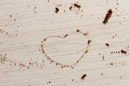 Heart shape from pices of black chocolate on wood background for valentine's dayの写真素材