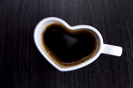 Cup with coffee shaped heart i love you on wood background
