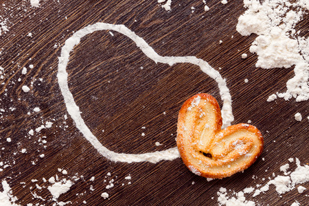 White heart shape from flour with cookie on wooden table. Concept "love cooking"の写真素材