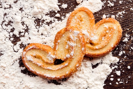 Cooking sweet cookies in shape of heart on wooden table with flour powder.  Concept "love cooking"の写真素材