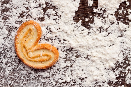 Cooking sweet cookies in shape of heart on wooden table with flour powder.  Concept "love cooking"の写真素材