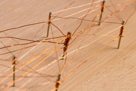 Bronze wire and nails on wooden backgroundの写真素材