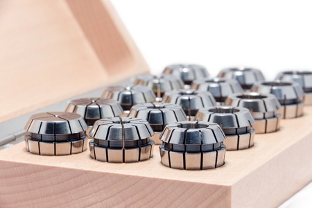 Metal collets for instruments for heavy industry in wooden box on white backgroundの写真素材