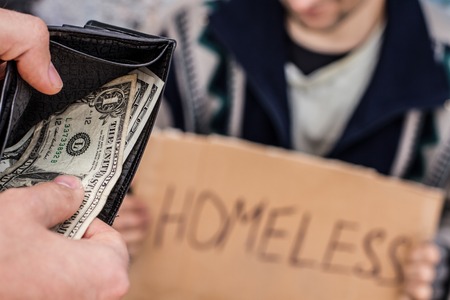 Someone is giving e few dollars to homeless manの写真素材