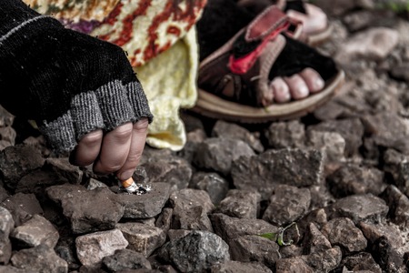 Close up shooting of homeless woman's hand crushing cigarette.の写真素材