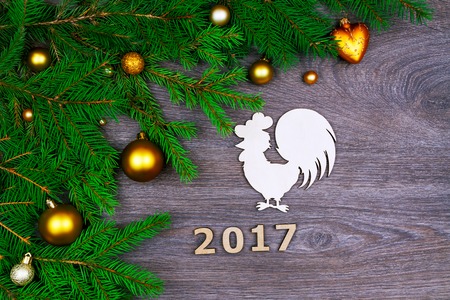 Green branches from christmas tree decorated with colorful balls,  wooden number of the next year...