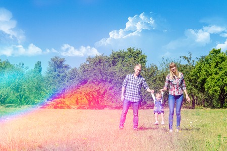 Happy family enjoying life together walking through the meadowの写真素材