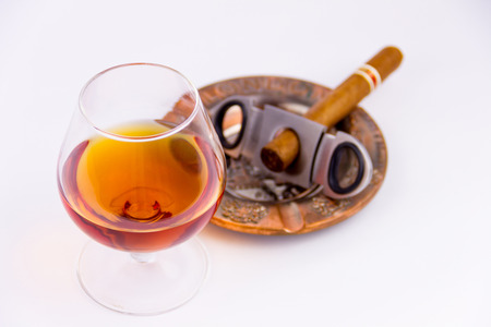 Cognac glass and cigar with ashtray isolated on white backgroundの写真素材